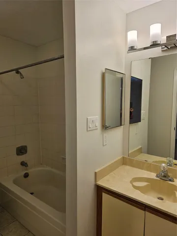 a bathroom with a granite countertop toilet and a bathtub