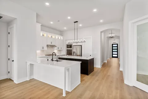 a kitchen with kitchen island a sink stainless steel appliances and cabinets