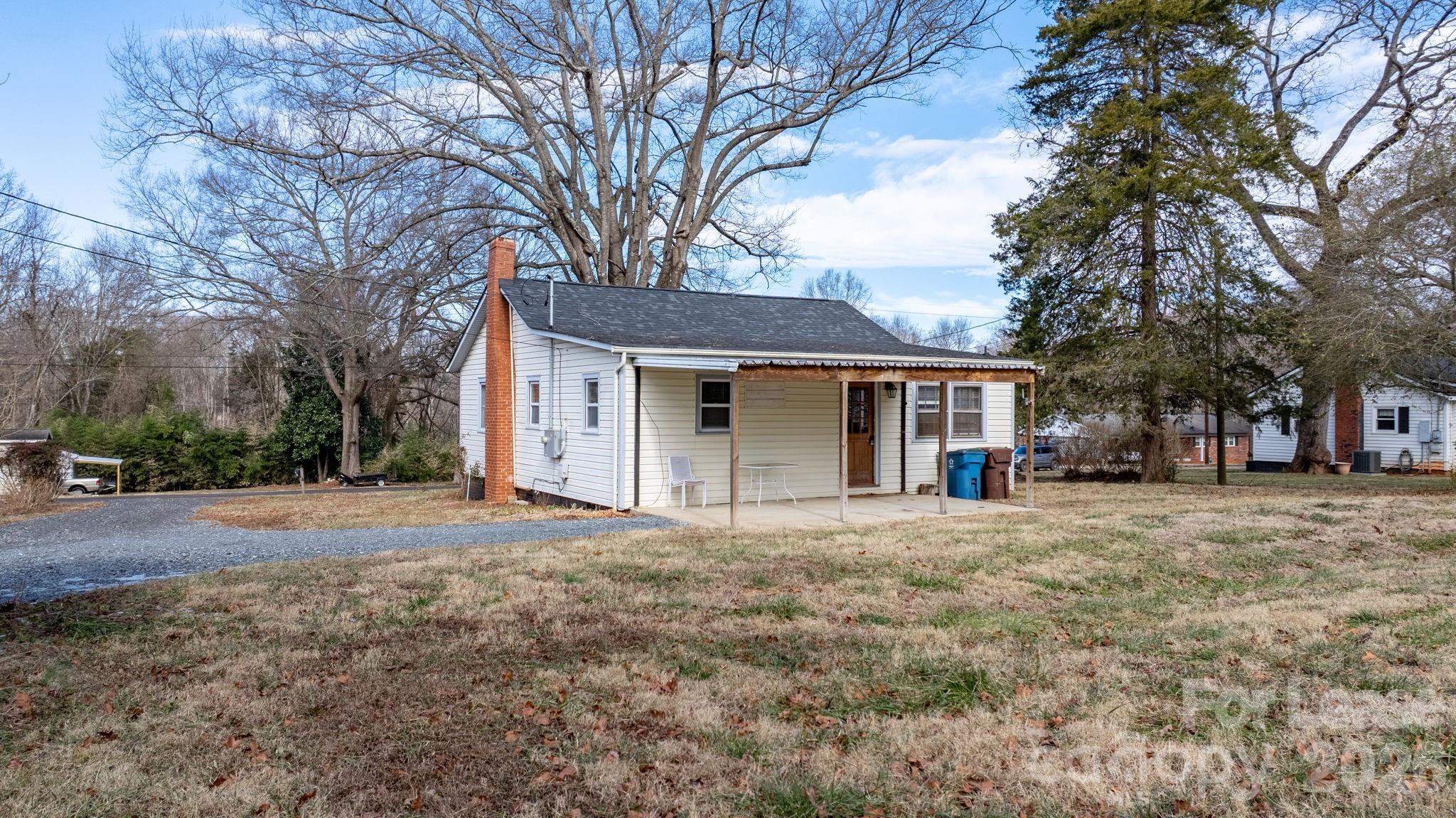 116 Barnes Lane Stony Point, NC 28678 - Photo 33 of 40 a front view of a house with a garden and trees