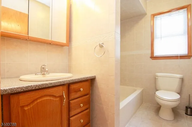 a bathroom with a granite countertop sink toilet and a mirror