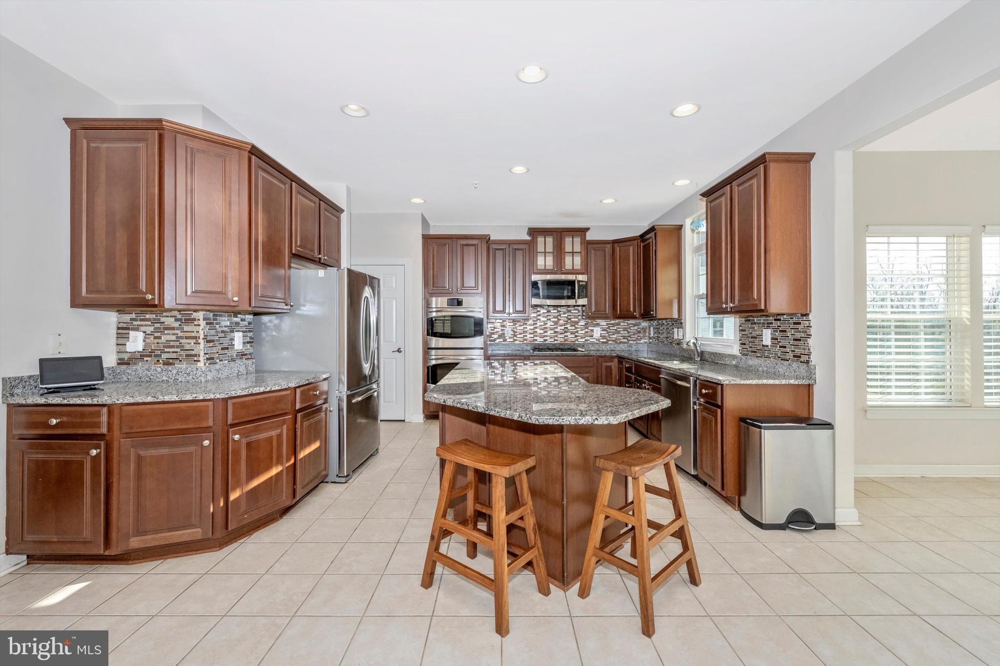 9121 Bealls Farm Road Frederick, MD 21704 - Photo 11 of 63 a kitchen with stainless steel appliances granite countertop wooden cabinets a sink and a stove