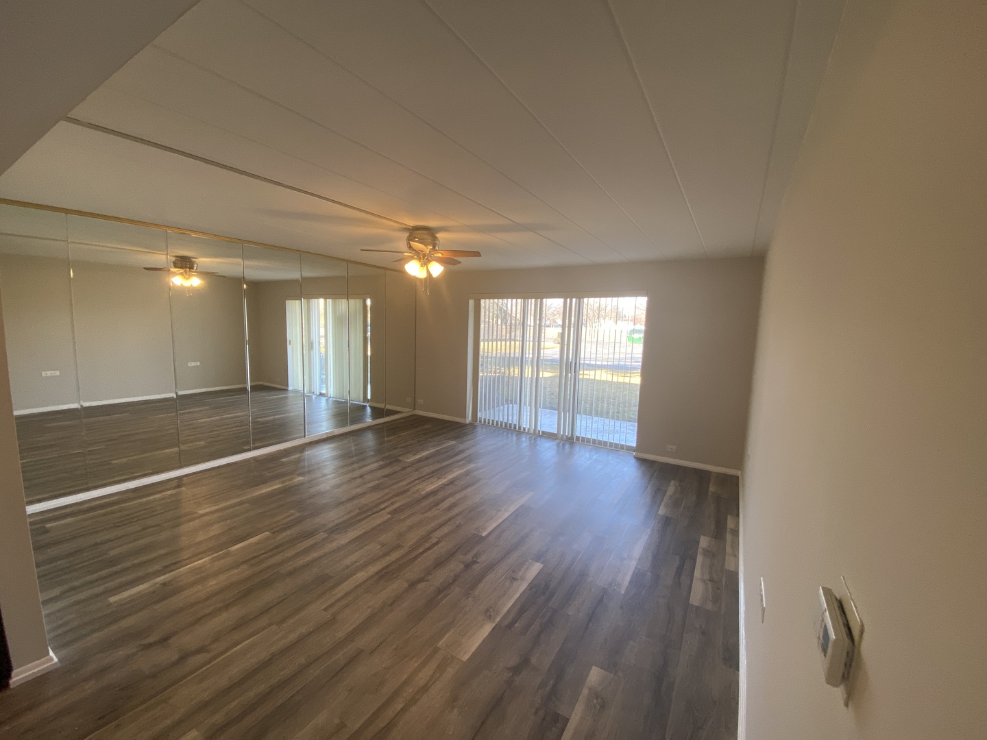 127 North Wolf Road, Unit 56A Wheeling, IL 60090 - Photo 4 of 13 an empty room with wooden floor and windows