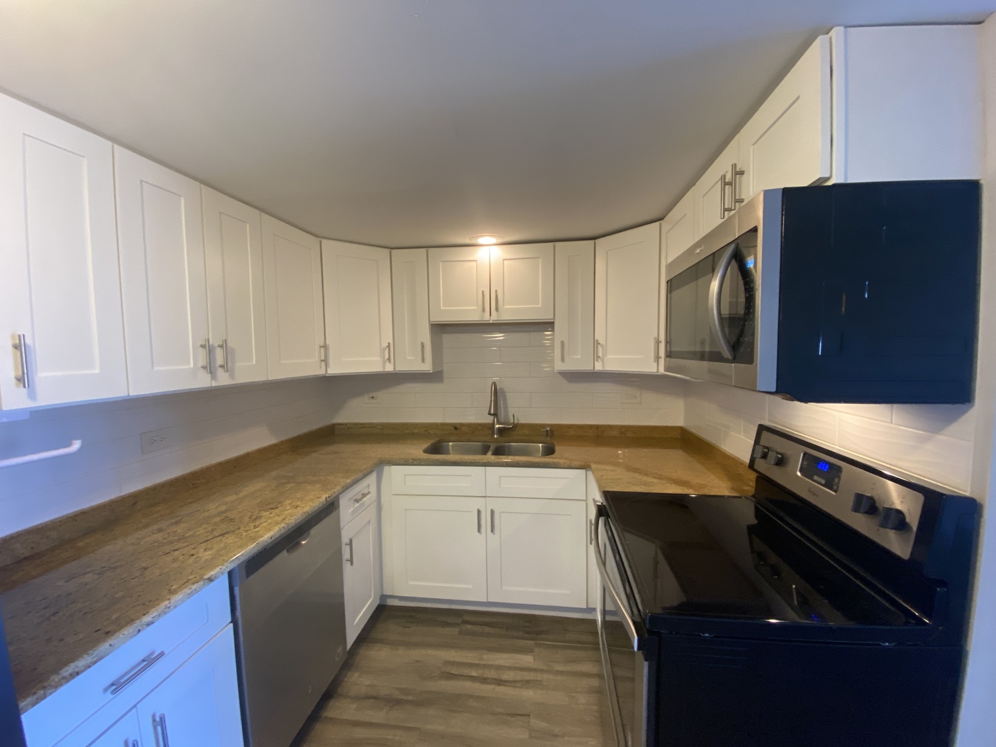 127 North Wolf Road, Unit 56A Wheeling, IL 60090 - Photo 6 of 13 a kitchen with stainless steel appliances granite countertop a sink stove and cabinets