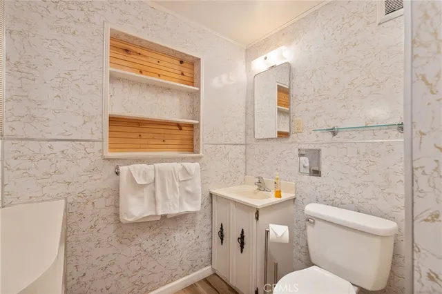 a bedroom with a bed and a flat tv screen on dresser