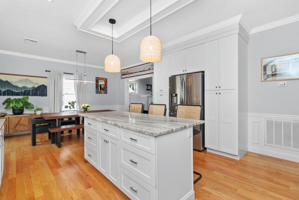 20 College Farm Road Waltham, MA 02451 - Photo 6 of 32 a room with kitchen island granite countertop a sink dishwasher a dining table and chairs with wooden floor
