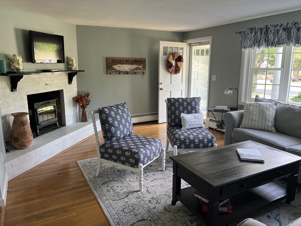 31 Haley Road, Unit A Marblehead, MA 01945 - Photo 2 of 18 a living room with furniture a flat screen tv and a fireplace