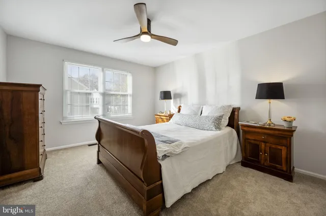 a bedroom with a bed and a ceiling fan