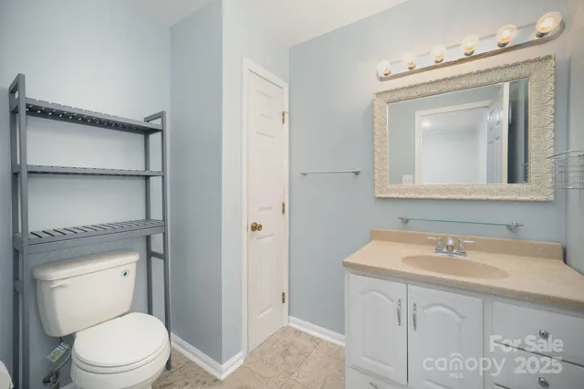 a bathroom with a sink vanity mirror and toilet