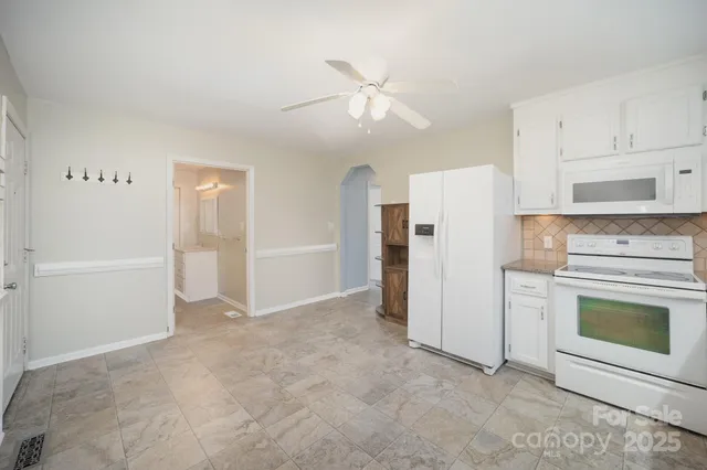 a view of a kitchen with refrigerator and cabinets