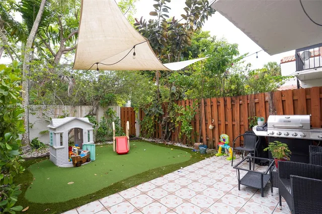 a view of a chair and table in backyard of the house