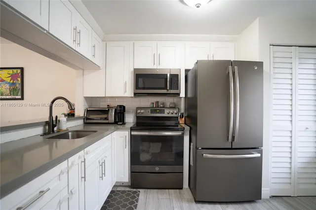 a kitchen with a refrigerator stove and sink