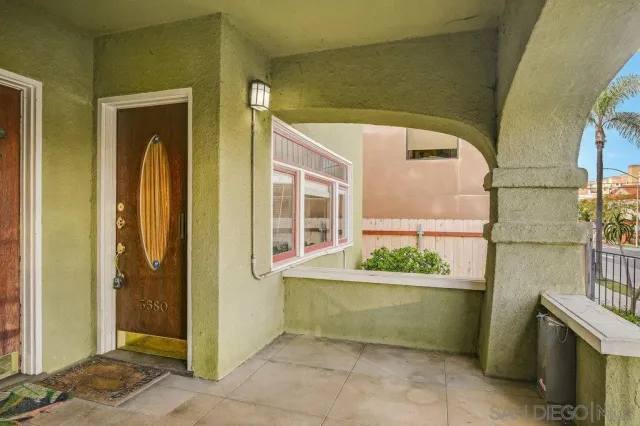 a view of an empty room with a fireplace and a window