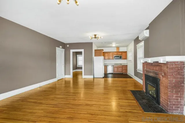 a view of an empty room with window and fire place