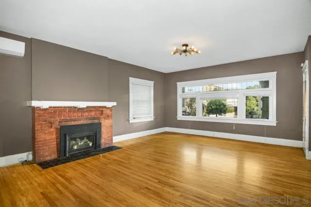a view of an empty room with a window and fireplace