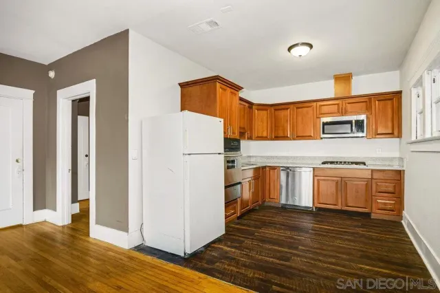 a kitchen with stainless steel appliances granite countertop a stove microwave and sink
