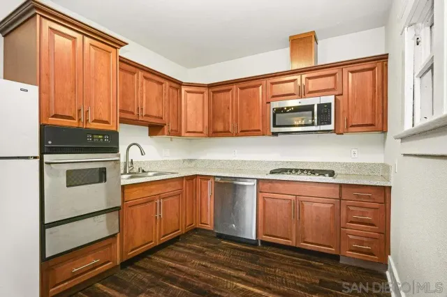 a kitchen with stainless steel appliances granite countertop a sink stove and microwave