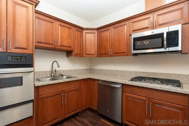 a kitchen with stainless steel appliances granite countertop a refrigerator sink and cabinets