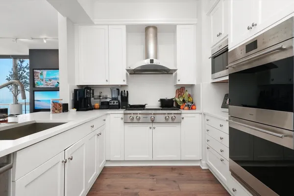a kitchen with stainless steel appliances white cabinets and a stove a oven