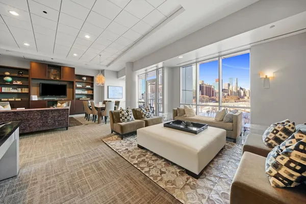 a living room with furniture a table and kitchen view