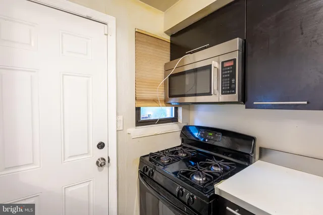 a kitchen with stainless steel appliances a stove and a microwave