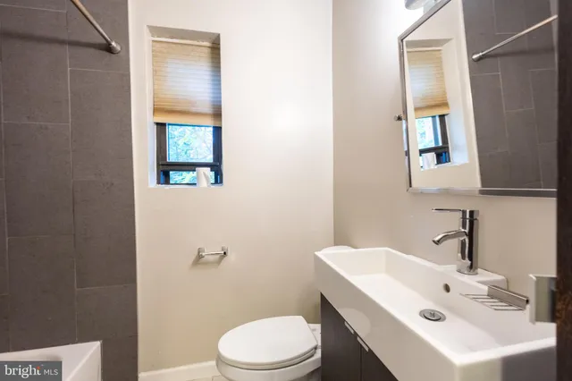 a bathroom with a sink mirror and toilet