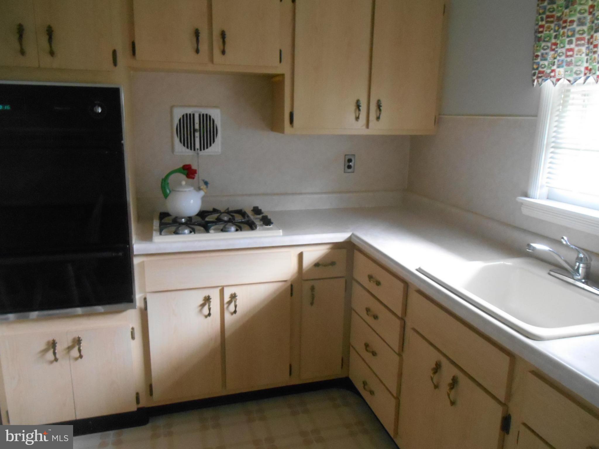 1414 Shefford Road Baltimore, MD 21239 - Photo 4 of 12 a kitchen with granite countertop white cabinets and white appliances