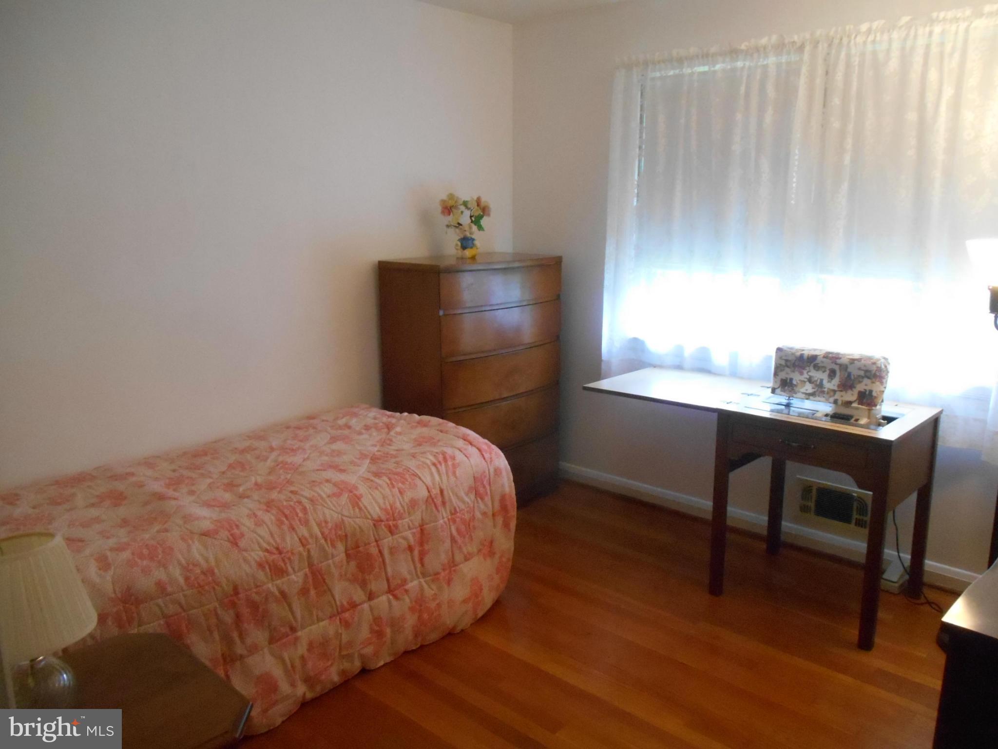 1414 Shefford Road Baltimore, MD 21239 - Photo 8 of 12 a bedroom with a bed and a table in it