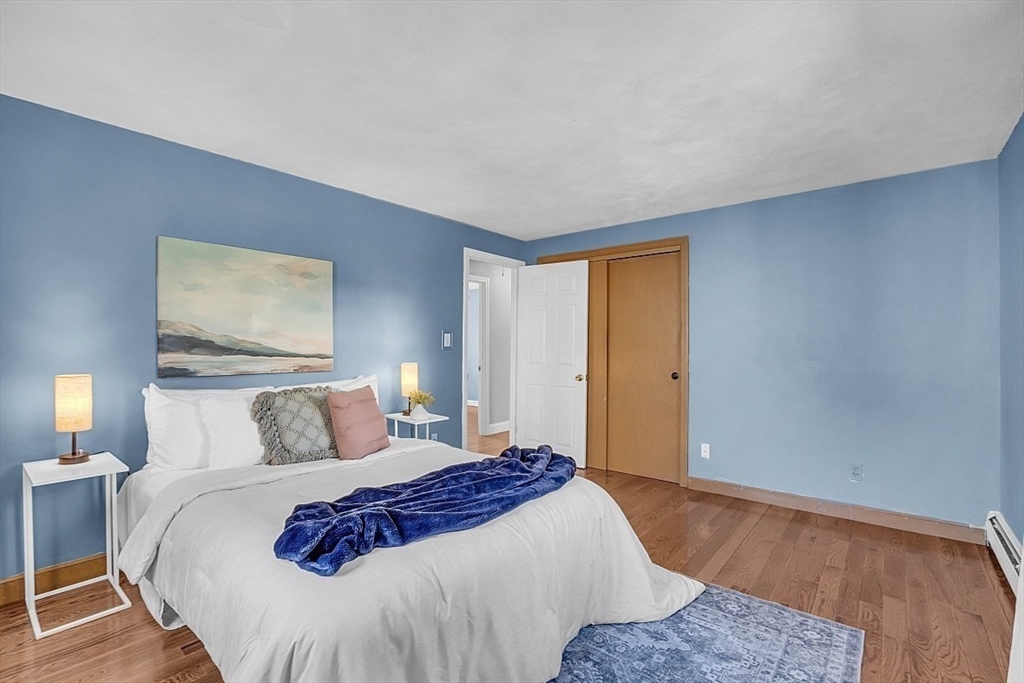31 Hemlock Road Reading, MA 01867 - Photo 18 of 28 a bedroom with a large bed and a lamp on dresser