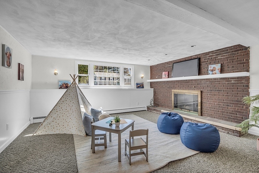 31 Hemlock Road Reading, MA 01867 - Photo 21 of 28 a living room with furniture and a fireplace