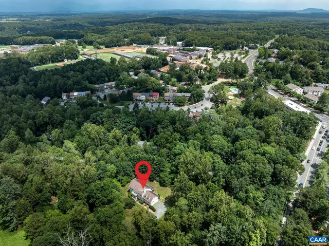 an aerial view of residential houses with outdoor space and trees