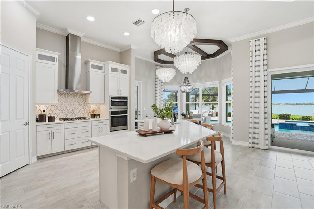 14882 Blue Bay Circle Fort Myers, FL 33913 - Photo 12 of 50 a kitchen with stainless steel appliances kitchen island granite countertop a table and chairs in it