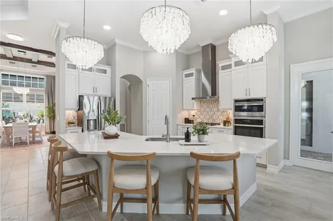 a dining room filled chandelier and wooden floor