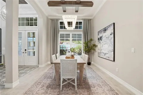 a dining room with furniture a large window and a chandelier
