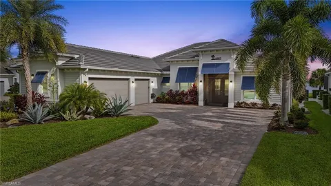 a front view of a house with a yard and potted plants