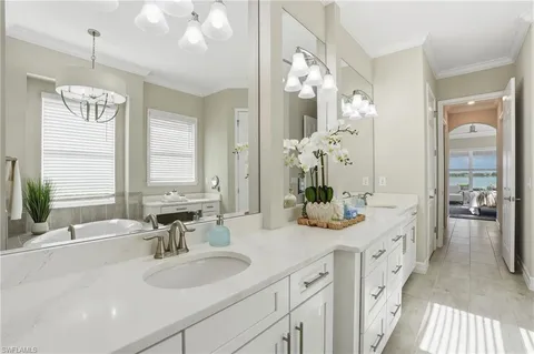 a spacious bathroom with a double vanity sink large mirror and a bathtub