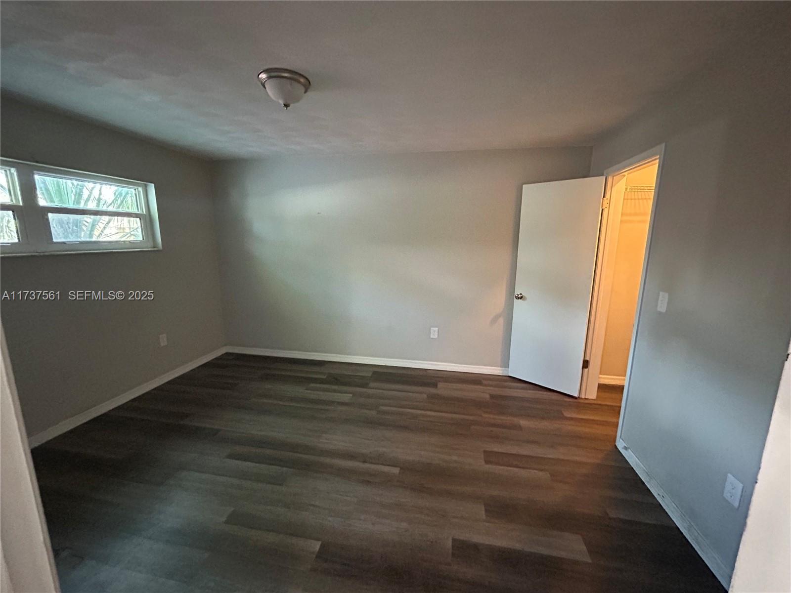 7403 Foxbloom Drive Port Richey, FL 34668 - Photo 16 of 45 a view of an empty room with wooden floor and a window
