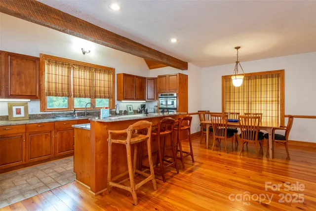 a large kitchen with lots of furniture a sink appliances and cabinets