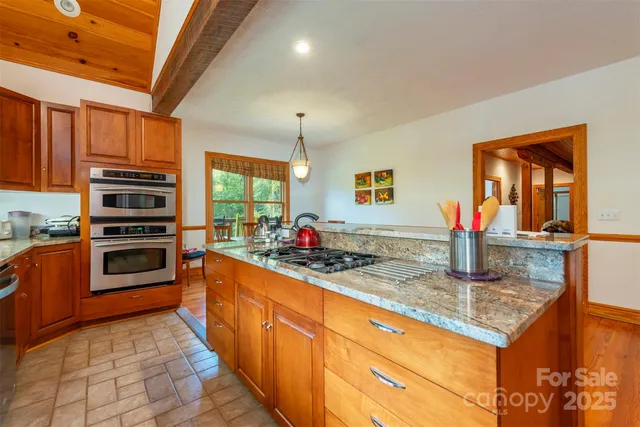 a kitchen with stainless steel appliances granite countertop a stove sink and cabinets