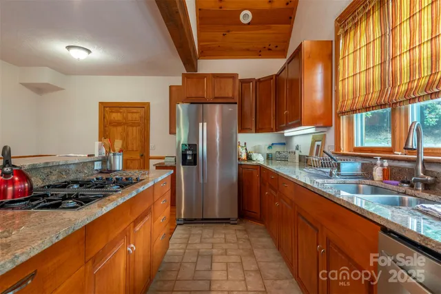 a kitchen with stainless steel appliances granite countertop a sink stove and refrigerator