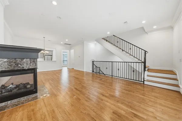 a view of a livingroom with wooden floor and a kitchen space