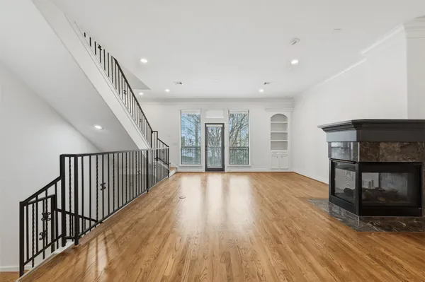 a view of a hallway with wooden floor and staircase