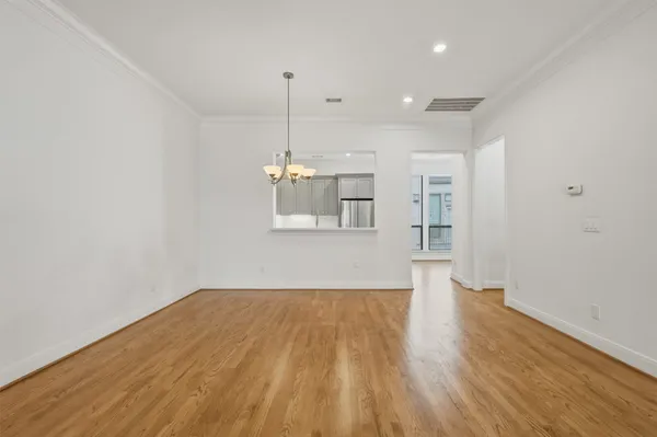 a view of empty room with wooden floor and window