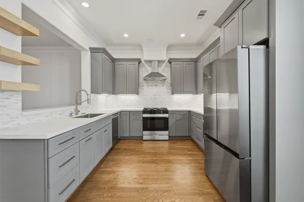a large kitchen with stainless steel appliances granite countertop a refrigerator and a sink