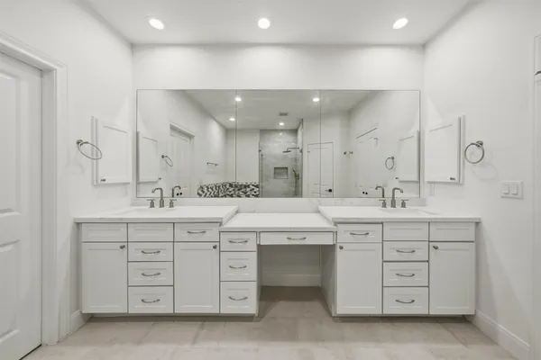 a spacious bathroom with a double vanity sink a large mirror and a