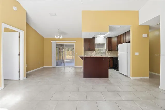 a view of a kitchen with furniture and an empty room