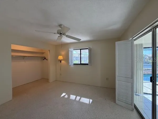 en empty room with windows and ceiling fan