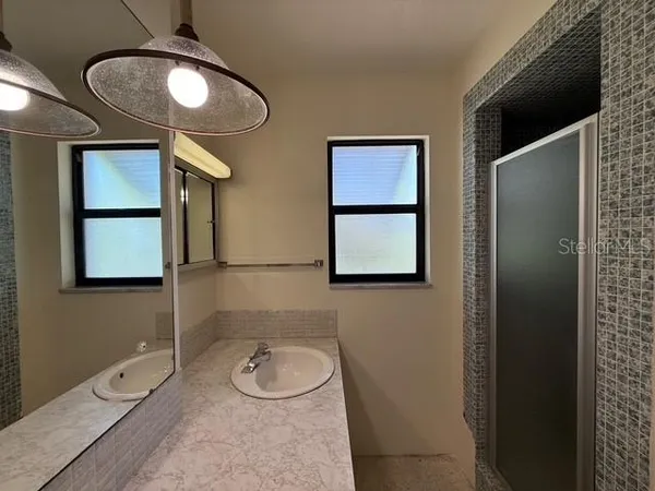 a bathroom with a granite countertop sink and a mirror