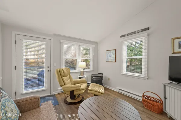 a living room with furniture a flat screen tv and a window