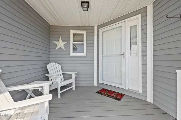 a view of wooden door and chairs in patio