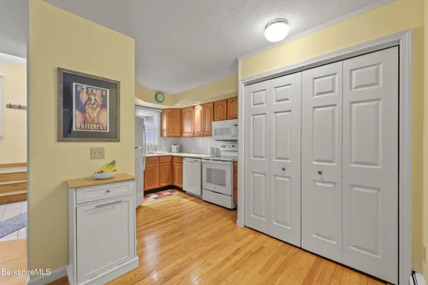 a kitchen with white cabinets and wooden floors